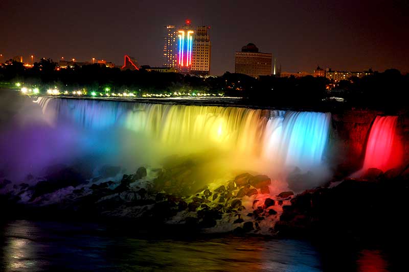 Niagara Falls at night lit up with the colors of the rainbow